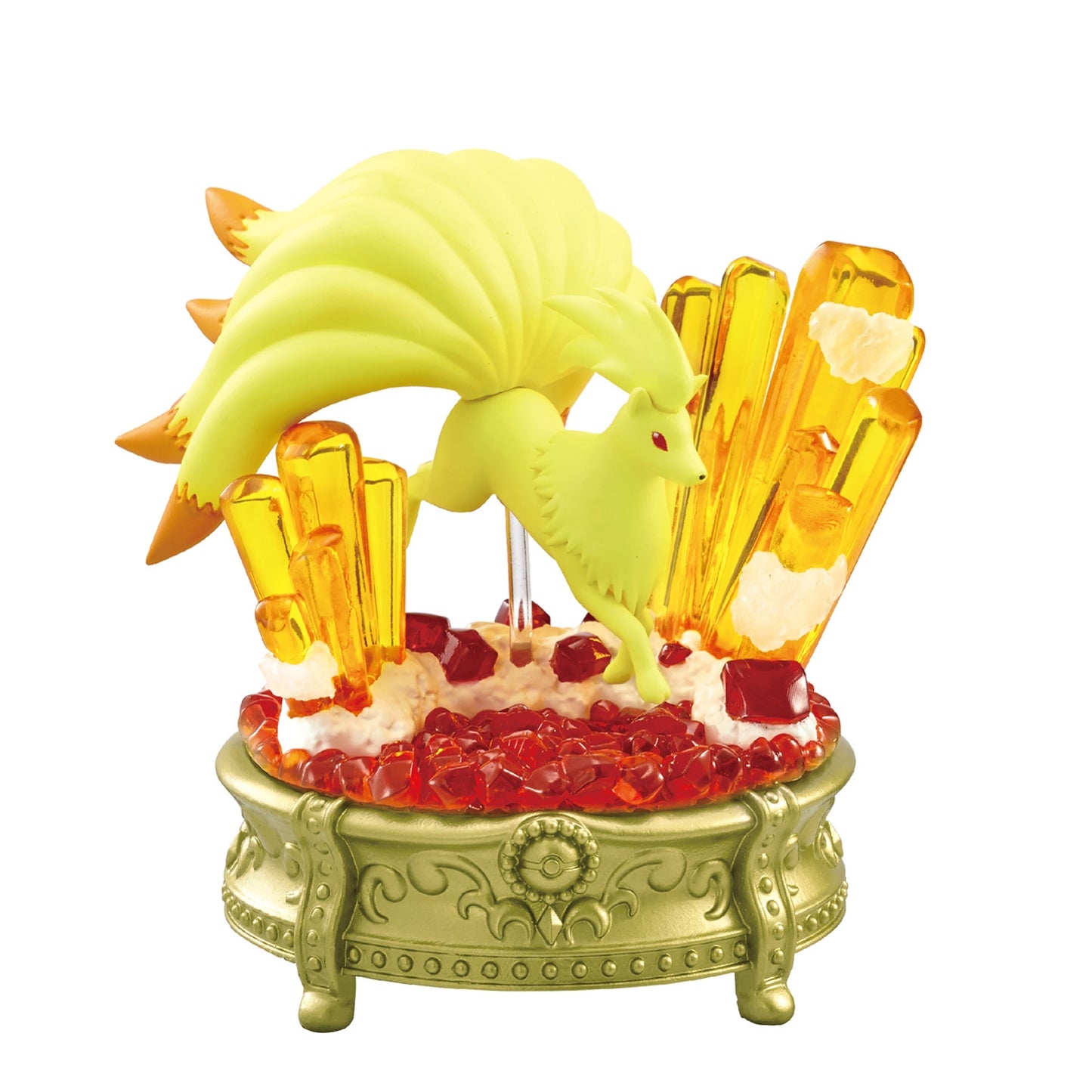 A decorative figure of Ninetales from Pokémon, posed mid-leap above a fiery scene with translucent red gems and tall orange crystals. The base is gold with ornate patterns, highlighting the vibrant and mystical design.
